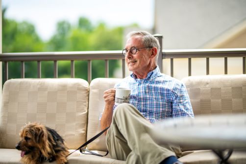 Man relaxing on porch with his dog